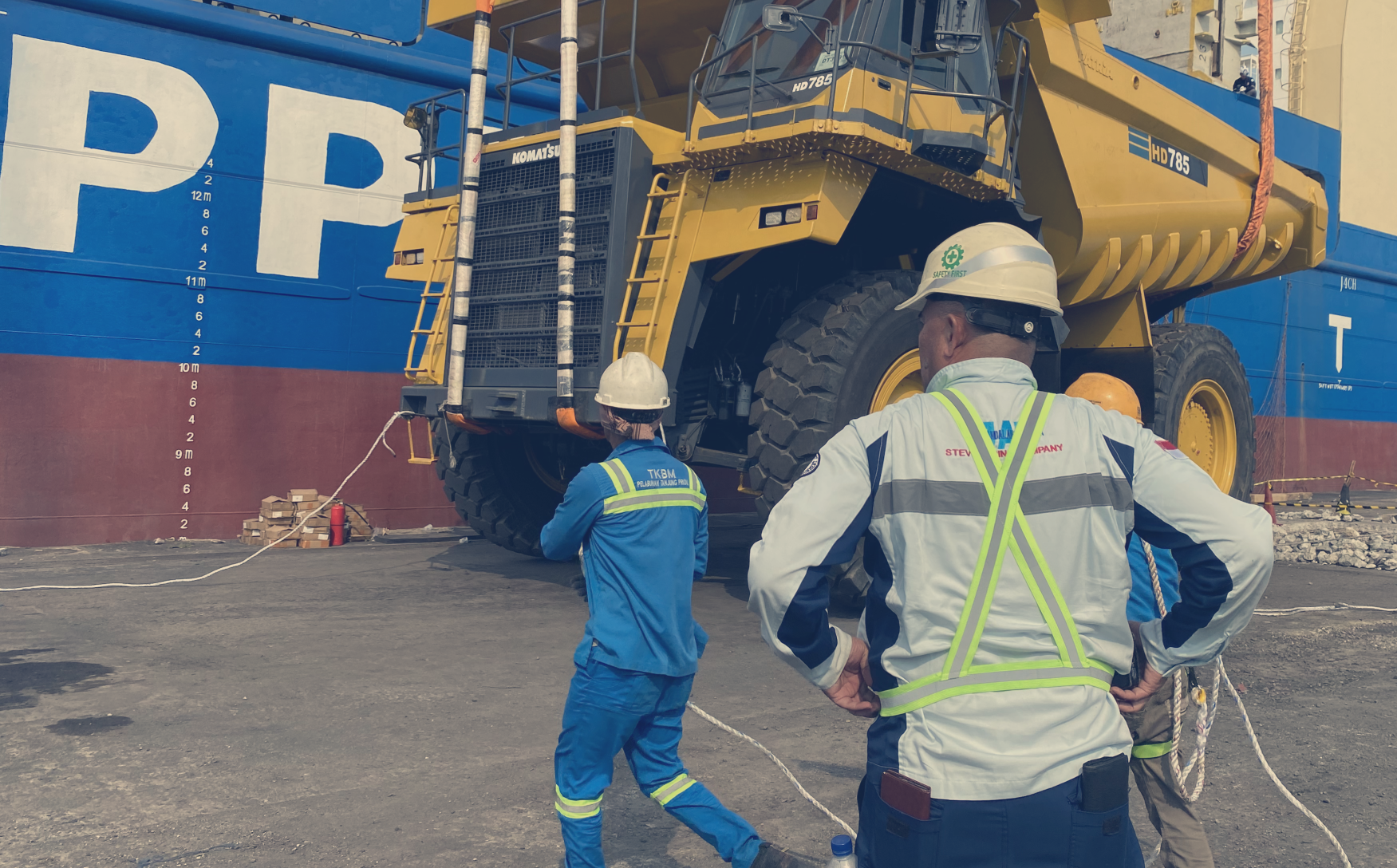 Supervised offloading of Komatsu HD785 haul truck, emphasizing safety and coordination